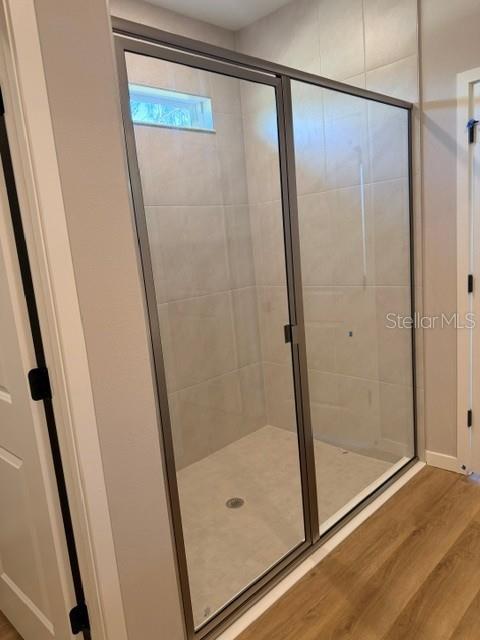A walk-in shower with a glass door and light-colored tile walls in a bathroom — 5792 SW 117TH LANE ROAD, OCALA, FL