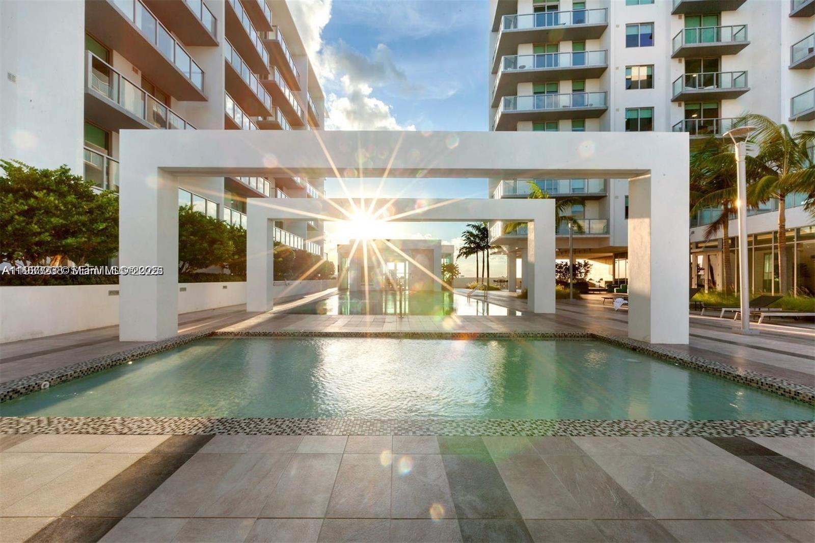 A swimming pool sits between two large white rectangular archways at an apartment complex — 3900 Biscayne Blvd # 905, Miami FL 33137, MIAMI, FL