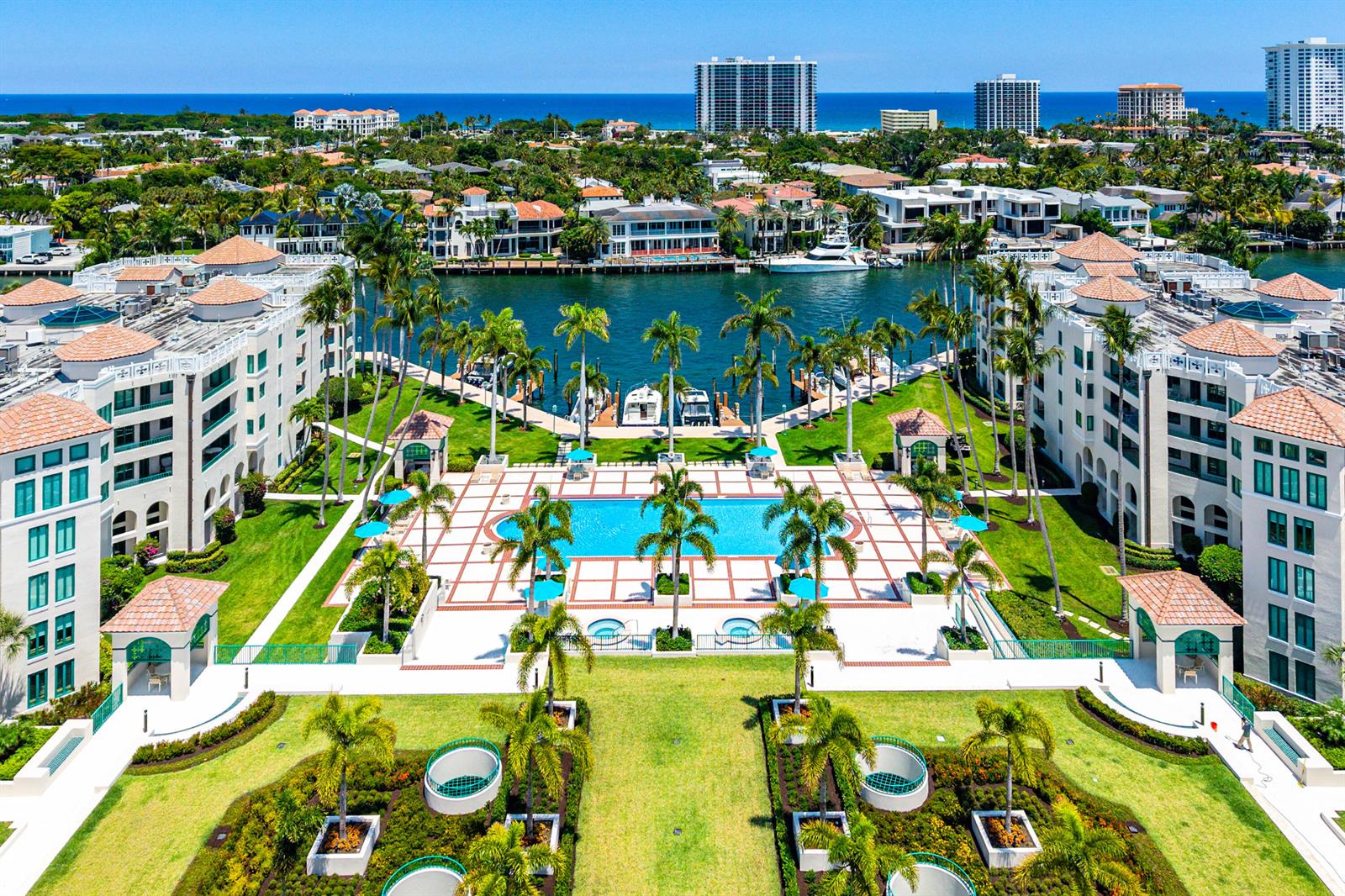 An aerial view of a waterfront apartment complex featuring a central swimming pool and courtyard — 100 SE 5th Avenue # 410, Boca Raton FL 33432, BOCA RATON, FL