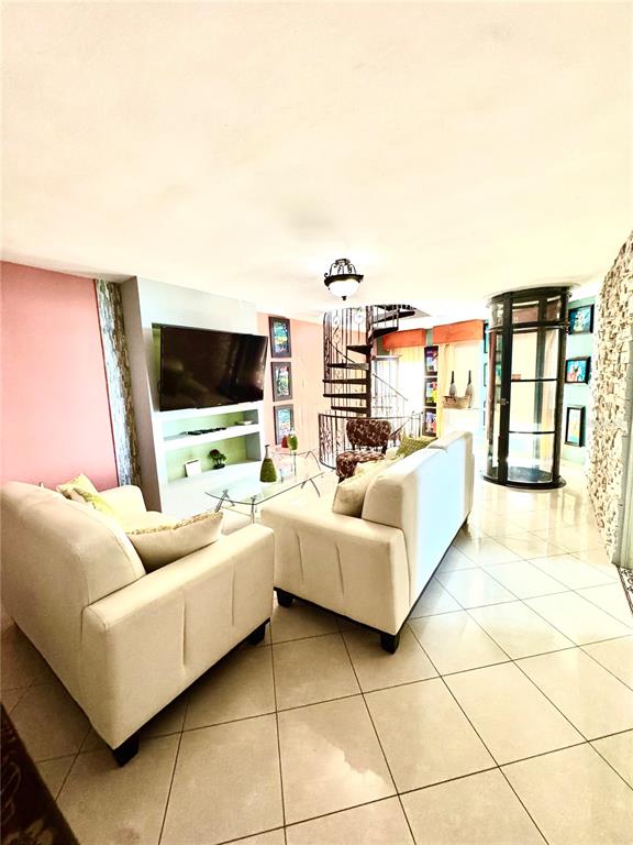 A living room features white sofas, a glass coffee table, and a spiral staircase — Cambija CALLE CAMBIJA UNIT 401, RINCON, PR