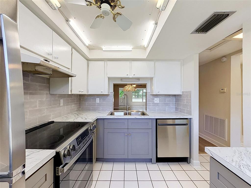 A single-story building with a metal roof, arched entryway, and green-trimmed stucco exterior — 4422 SUNSTATE DRIVE, NEW PORT RICHEY, FL