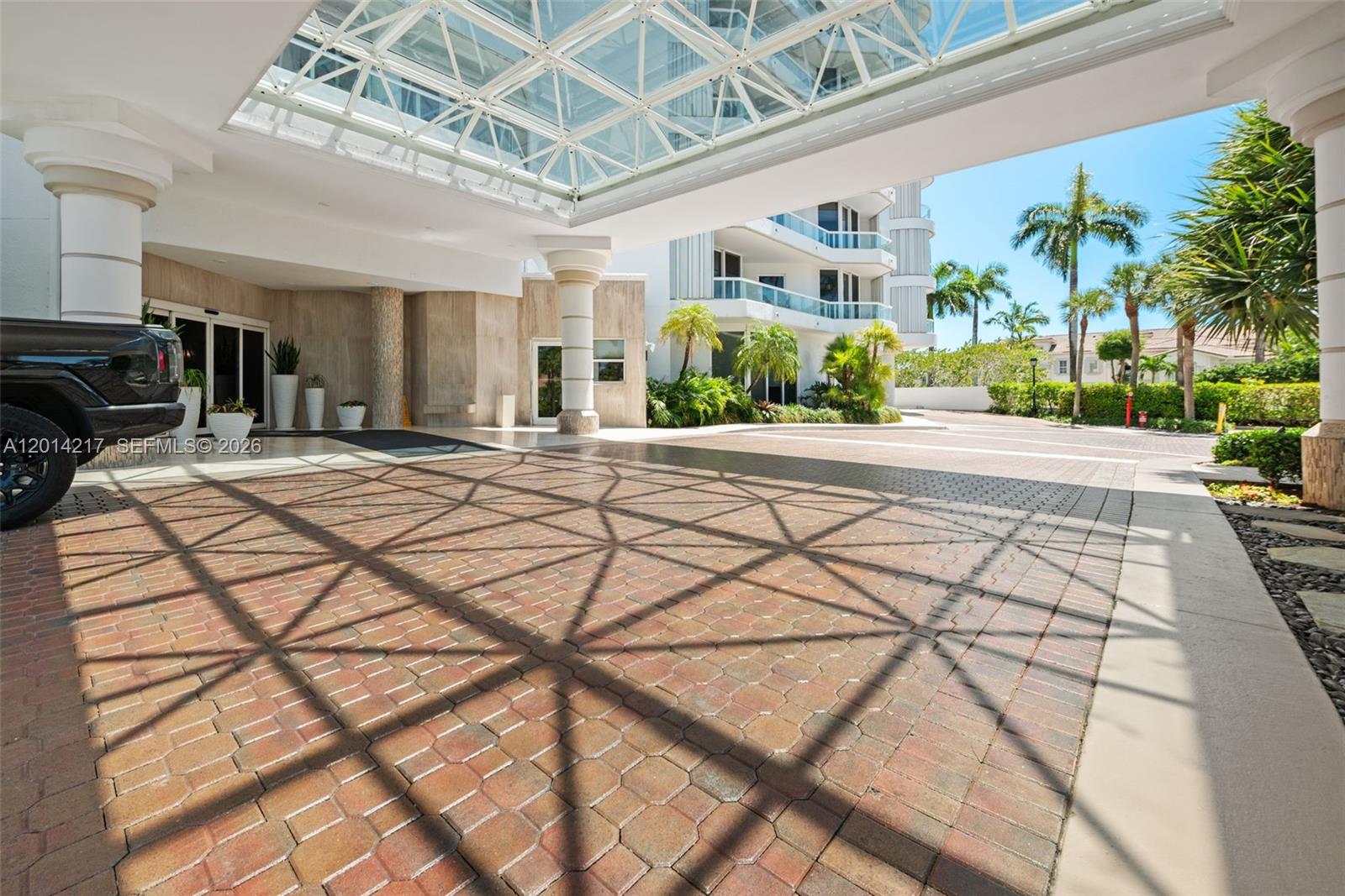 A paved driveway leads to a building entrance featuring a large glass-covered porte-cochère — 21050 Point Pl # 302, Aventura FL 33180, AVENTURA, FL