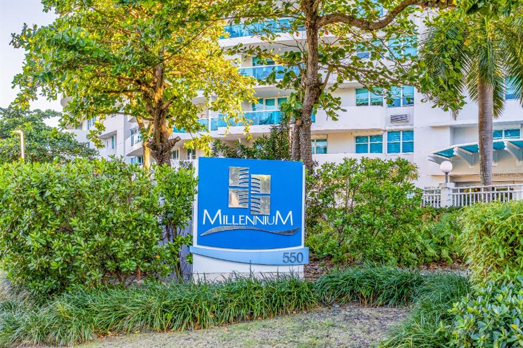 A blue sign for the Millennium building stands in front of a multi-story residential complex — 550 AVENIDA CONSTITUCION UNIT 810, SAN JUAN, PR