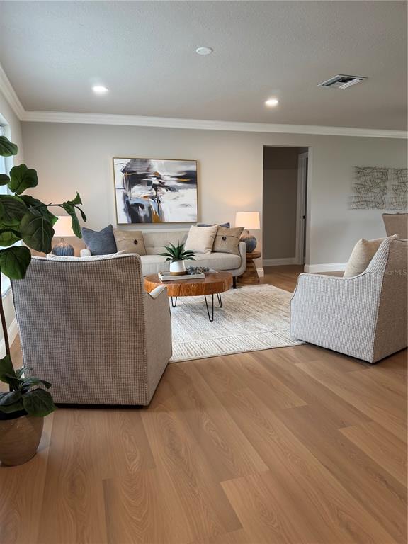 A kitchen island with a white countertop and navy base features three upholstered bar stools — 9608 41ST STREET N UNIT 2, PINELLAS PARK, FL