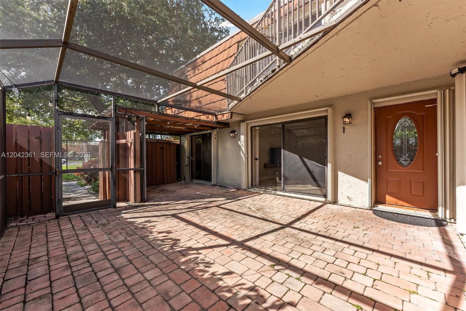 A living room features light tile floors, a staircase, and sliding glass doors to a patio — 11867 SW 13th Ct, Davie FL 33325, DAVIE, FL