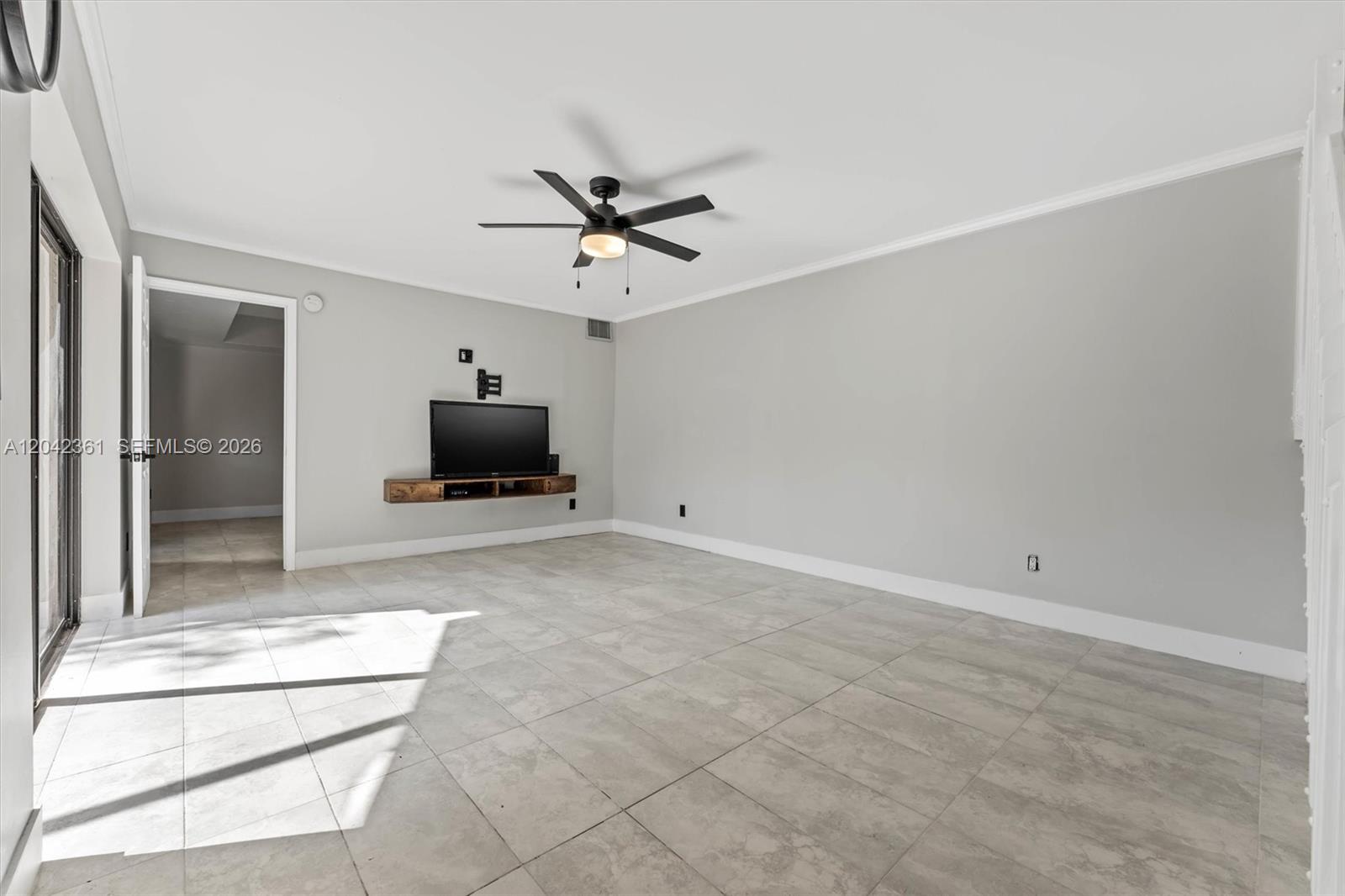 A living room features light gray walls, large floor tiles, a ceiling fan, and a television — 11867 SW 13th Ct, Davie FL 33325, DAVIE, FL