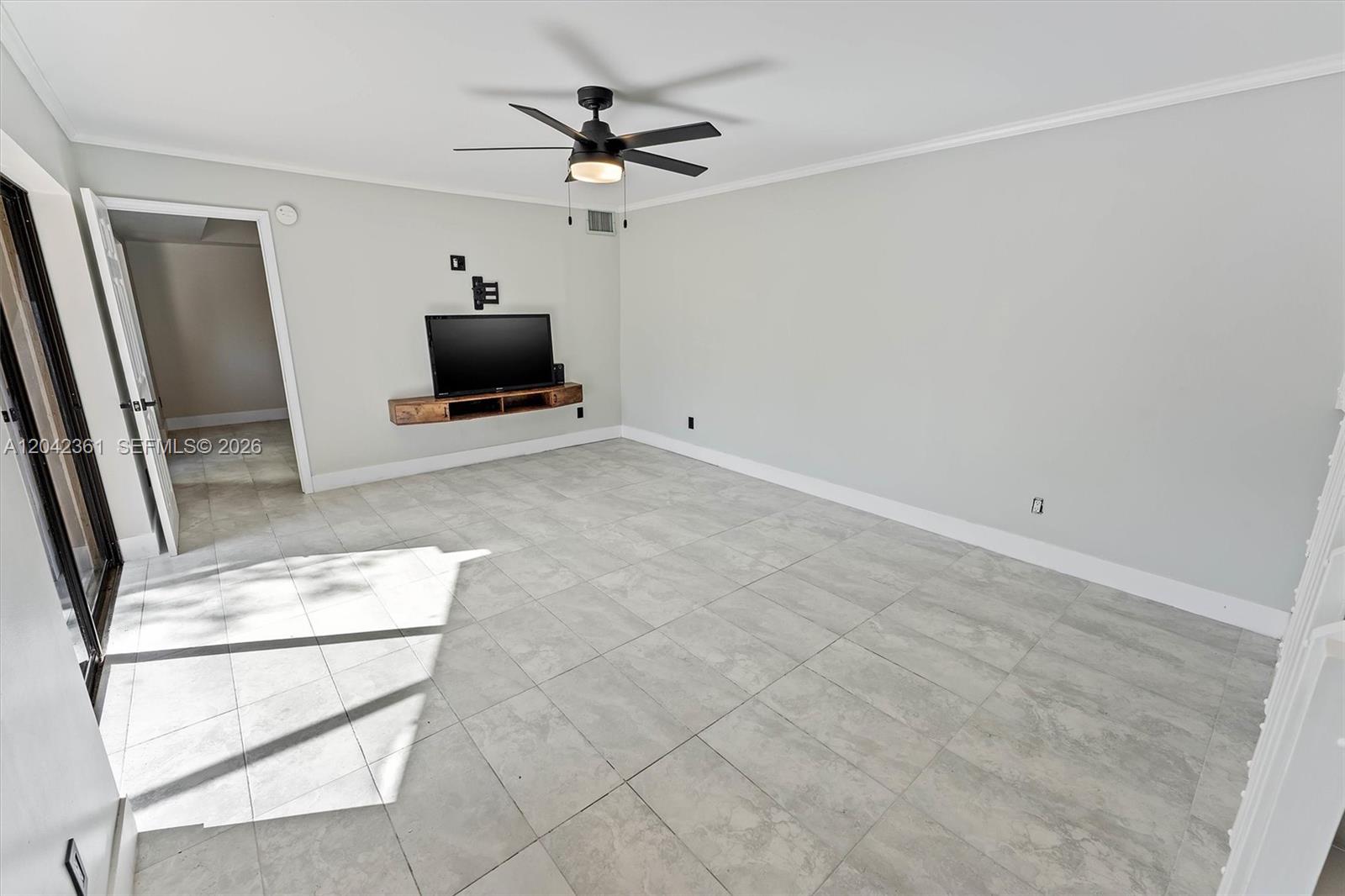 An empty room with light tile flooring, a ceiling fan, and sliding glass doors — 11867 SW 13th Ct, Davie FL 33325, DAVIE, FL