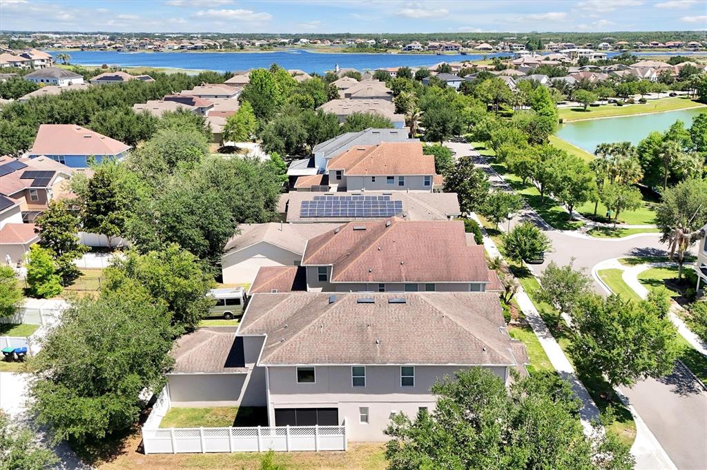 An aerial view shows a suburban neighborhood with houses, a lake, and green trees — 7922 WINTER WREN STREET, WINTER GARDEN, FL