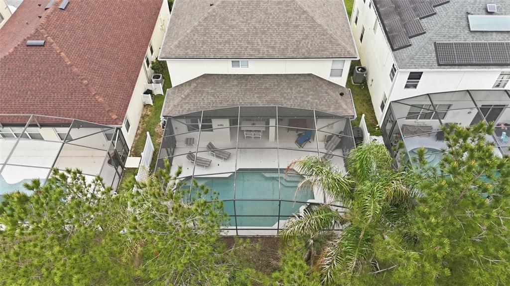 An aerial view shows a house with a screened-in pool and patio area — 133 BAY LEAF LANE, DAVENPORT, FL
