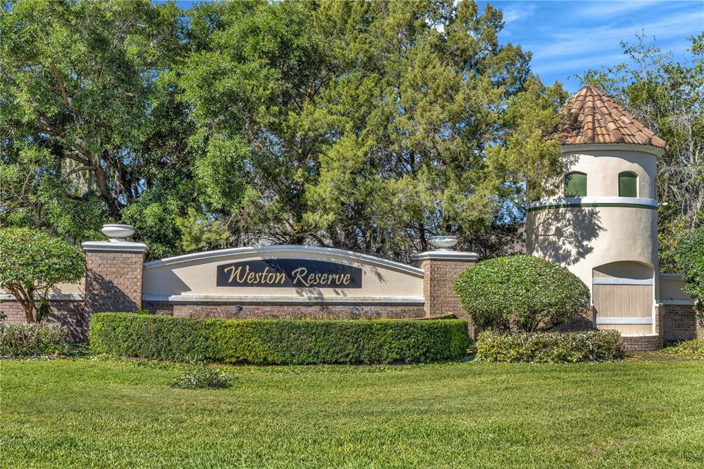 A stone and stucco monument sign for Weston Reserve stands in front of lush trees — 2989 WHITE CEDAR CIRCLE, KISSIMMEE, FL