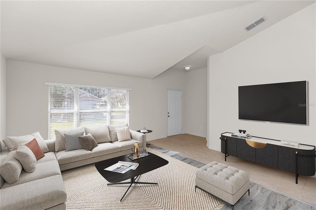 A living room features a sectional sofa, a coffee table, and a wall-mounted television — 2989 WHITE CEDAR CIRCLE, KISSIMMEE, FL
