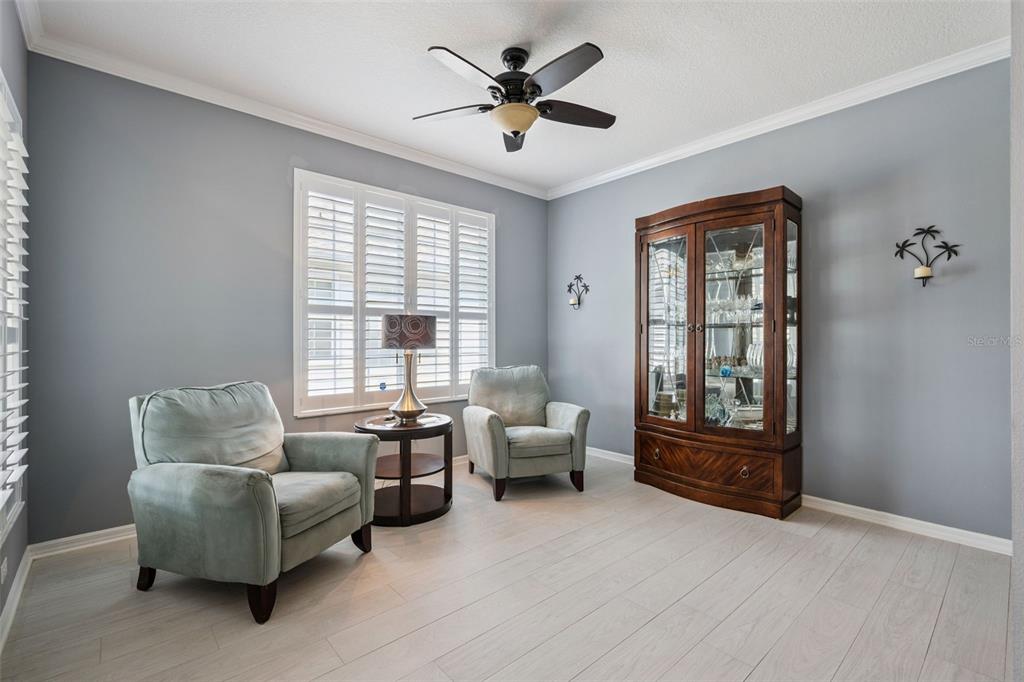 A living room features light gray walls, light wood floors, two armchairs, and a display cabinet — 9615 SWEETLEAF STREET, ORLANDO, FL