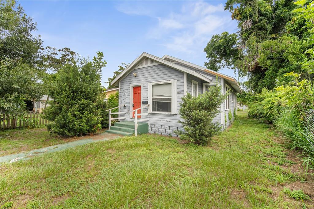 A small, light blue, single-story house with a red front door and green steps — 3535 14TH AVENUE S, ST PETERSBURG, FL