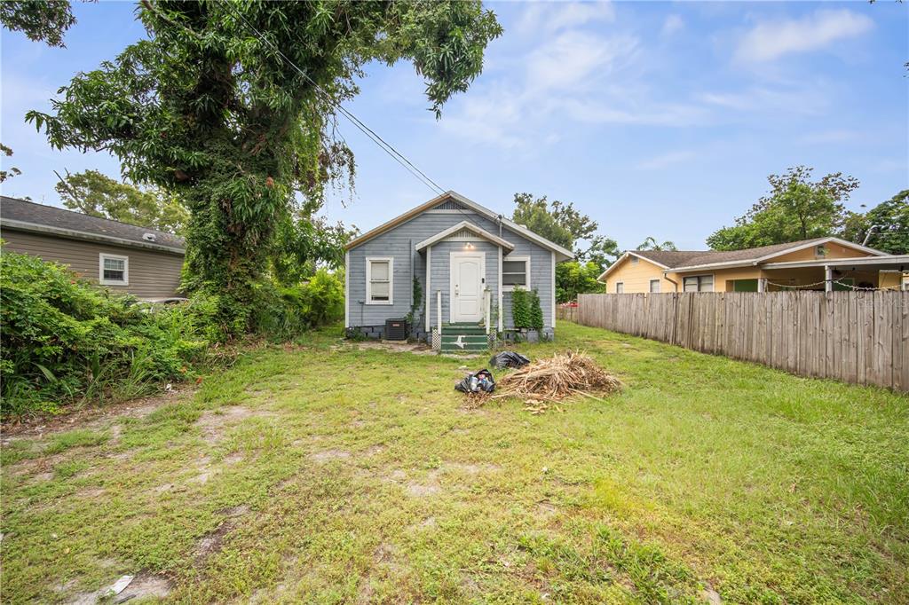 A small, light blue house with a front porch stands in a grassy yard — 3535 14TH AVENUE S, ST PETERSBURG, FL