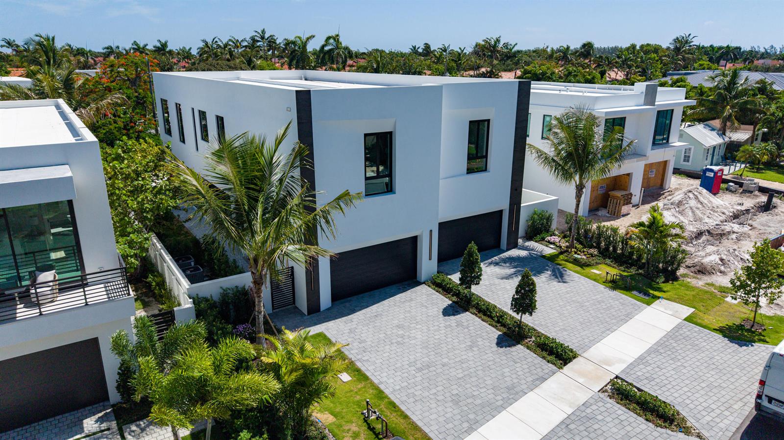 An aerial view of a modern two-story white house with a paved driveway and palm trees — 723 Lake Avenue N, Delray Beach FL 33483, DELRAY BEACH, FL