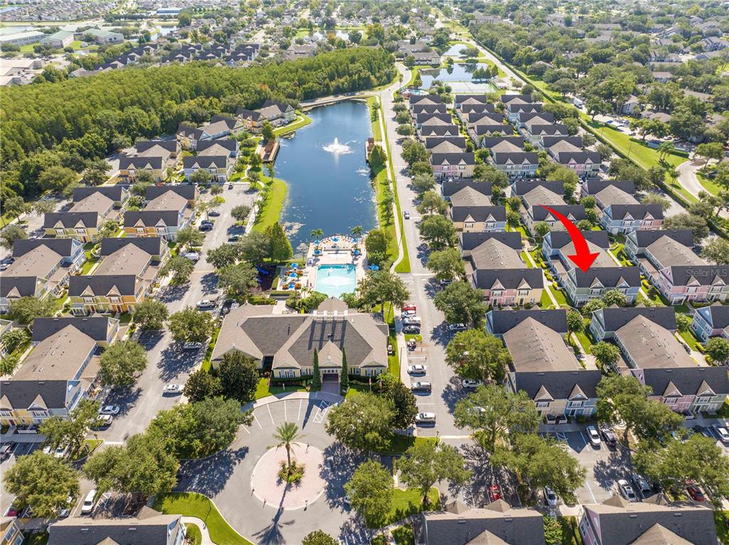 An aerial view shows a residential community with a central lake, pool, and clubhouse — 4011 VENETIAN BAY DRIVE UNIT 101, KISSIMMEE, FL
