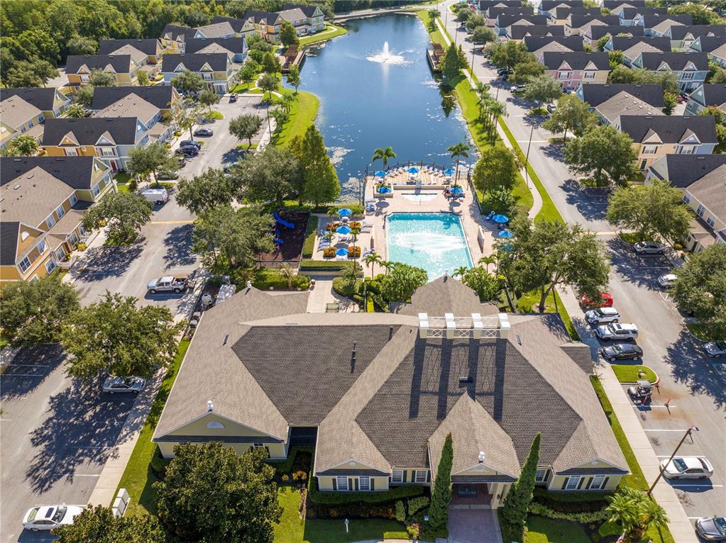 An aerial view shows a community clubhouse with a pool, fountain, and surrounding residential buildings — 4011 VENETIAN BAY DRIVE UNIT 101, KISSIMMEE, FL