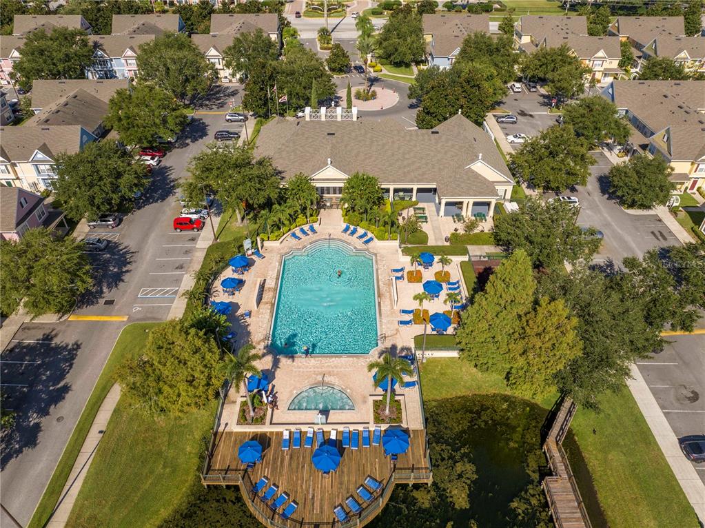 An aerial view shows a swimming pool and wooden deck surrounded by residential buildings — 4011 VENETIAN BAY DRIVE UNIT 101, KISSIMMEE, FL