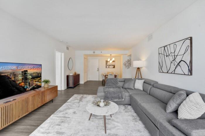 A living room features a grey sectional sofa, a marble coffee table, and a wooden console — 5225 Collins Ave # 1606, Miami Beach FL 33140, MIAMI BEACH, FL