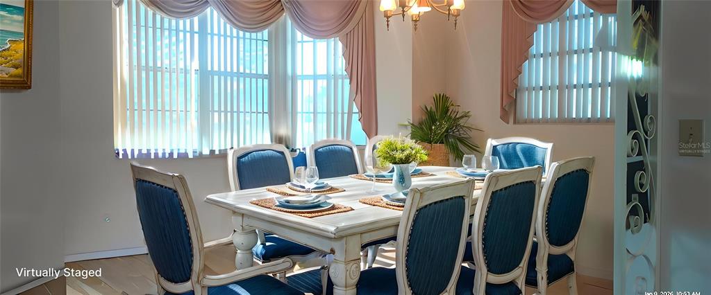 A dining room features a white wooden table with blue chairs and draped window treatments — 2201 S PENINSULA DRIVE, DAYTONA BEACH, FL