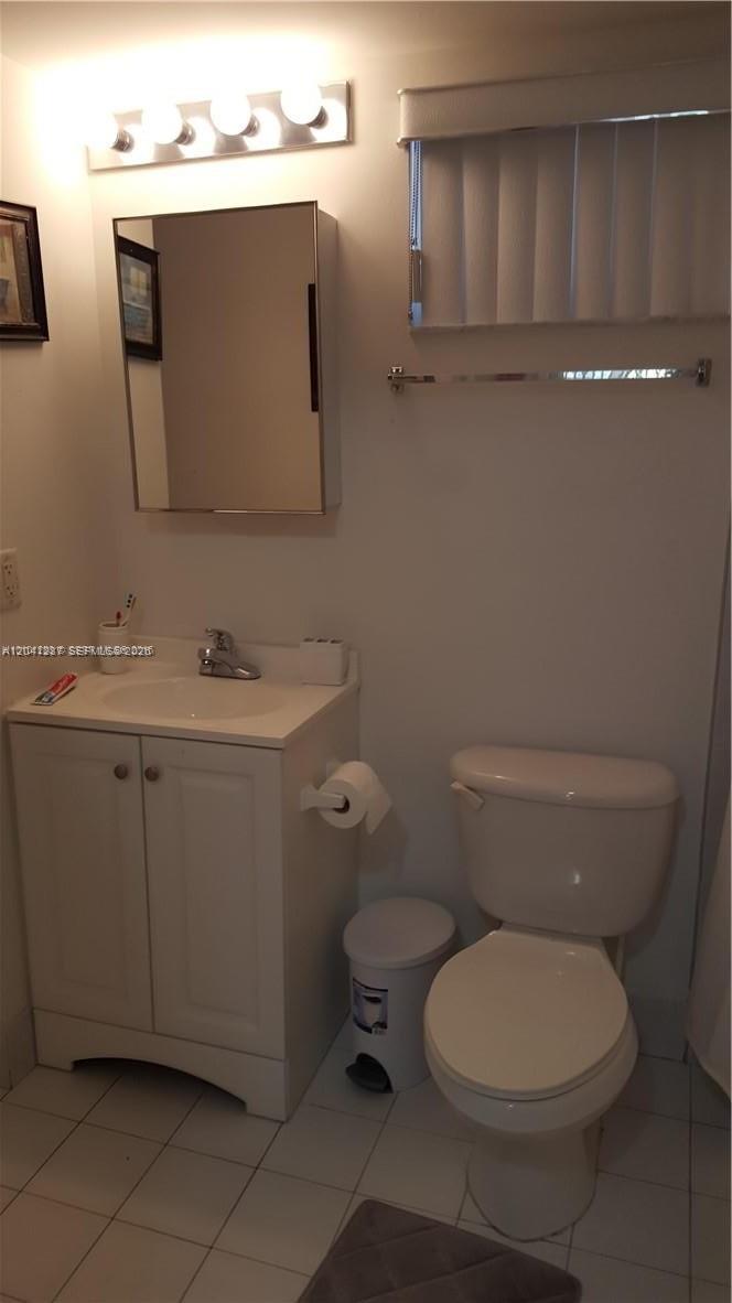 A bathroom features a white vanity with a sink, a medicine cabinet, and a toilet — 201 NW 7th St # 408, Miami FL 33136, MIAMI, FL