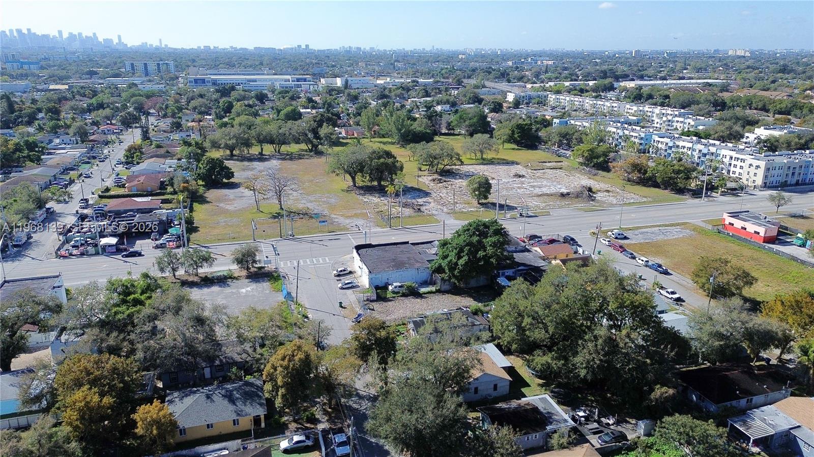 An aerial view shows a commercial building on a corner lot with adjacent vacant land — 1067 NW 79th St, Miami FL 33150, MIAMI, FL