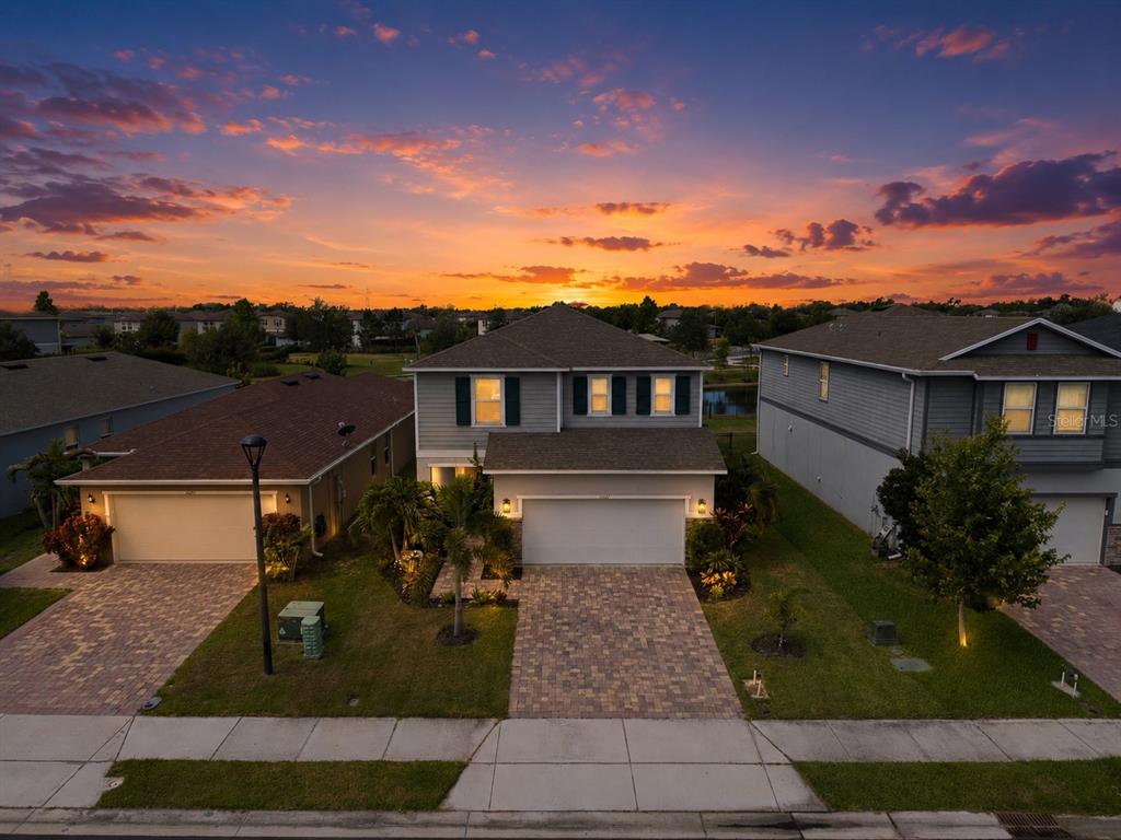 An aerial view of a two-story suburban house with a paved driveway at sunset — 11567 GALLATIN TRAIL, PARRISH, FL