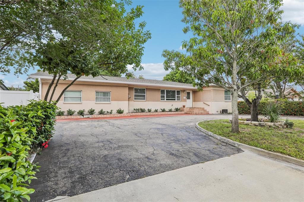 A single-story house with a beige exterior and a large, cracked asphalt driveway — 2709 49TH STREET N, ST PETERSBURG, FL