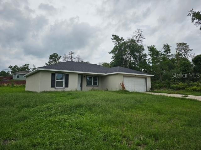 A single-story house with a light-colored exterior, a dark roof, and an attached garage — 2292 SW 168TH LOOP, OCALA, FL