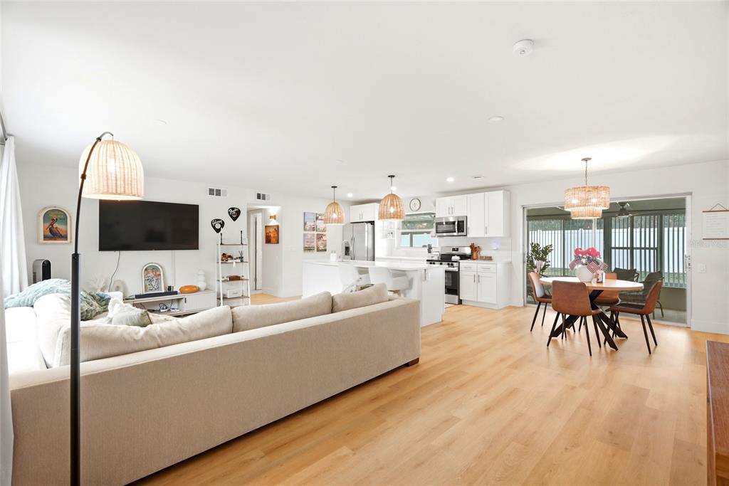 An open-concept living room and kitchen with light wood flooring and white cabinetry — 11500 70TH TERRACE, SEMINOLE, FL