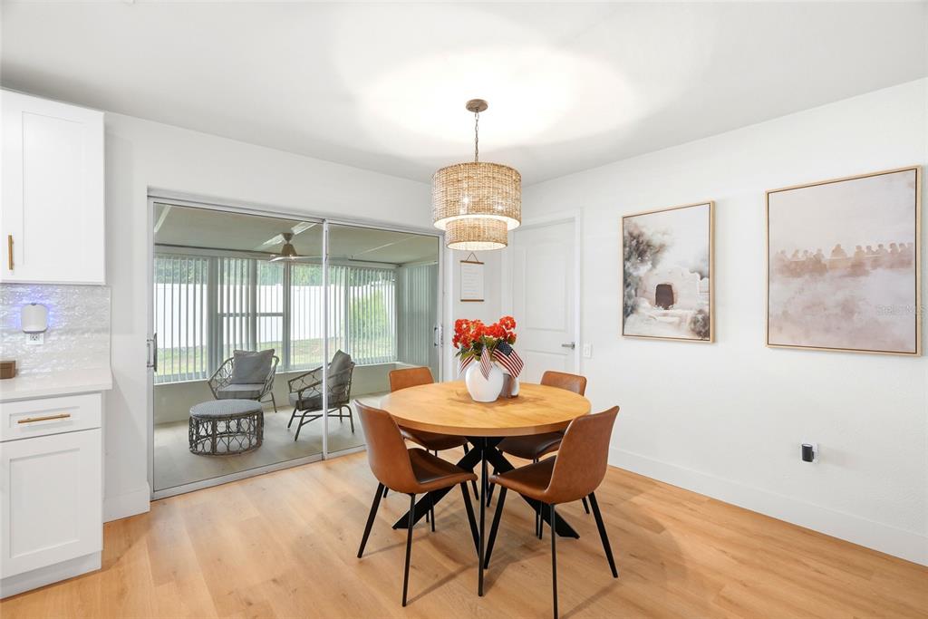 A dining area features a round wooden table, four brown chairs, and a sliding glass door — 11500 70TH TERRACE, SEMINOLE, FL