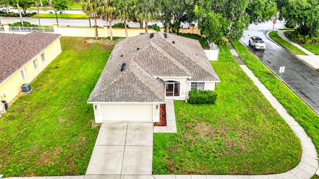 An aerial view shows a single-story house with a shingled roof and a concrete driveway — 1129 CONCH COURT, WESLEY CHAPEL, FL