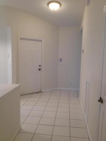 An entryway with white tile flooring, a white front door, and a ceiling light fixture — 8432 Cargill Point, West Palm Beach FL 33411, WEST PALM BEACH, FL