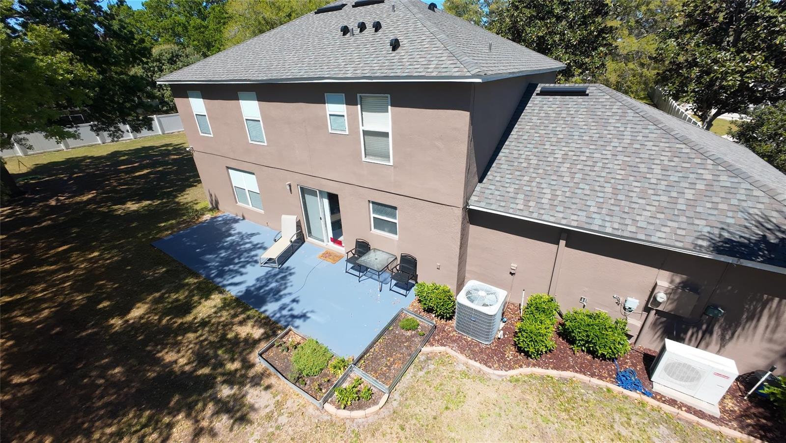 An aerial view of a two-story house exterior with a patio, garden beds, and yard — 921 Westcliffe Drive, Winter Garden FL 34787, WINTER GARDEN, FL