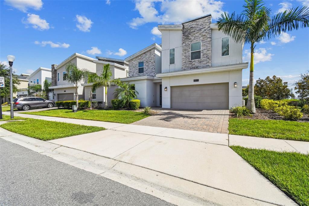 A two-story house with a stone facade, a two-car garage, and a paved driveway — 8844 CRUDEN BAY COURT, DAVENPORT, FL