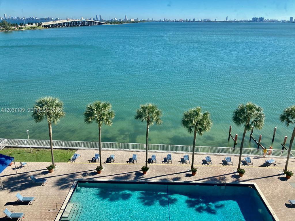 An elevated view of a swimming pool, palm trees, and a bay with a bridge — 3301 NE 5th Ave # 706, Miami FL 33137, MIAMI, FL