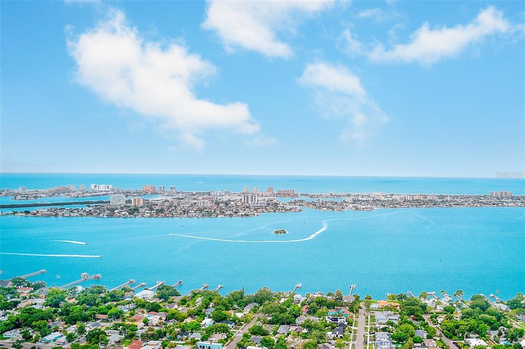 An aerial view shows a coastal residential area overlooking a large bay and city skyline — 1011 FAIRMONT STREET, CLEARWATER, FL