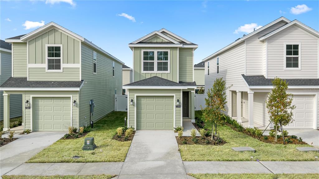 Three suburban houses with green and white siding stand side-by-side along a sidewalk — 9193 SW 71ST COURT, OCALA, FL
