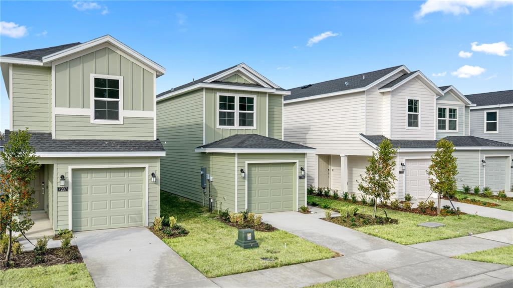 A row of modern two-story suburban houses with garages and green lawns under a blue sky — 9193 SW 71ST COURT, OCALA, FL