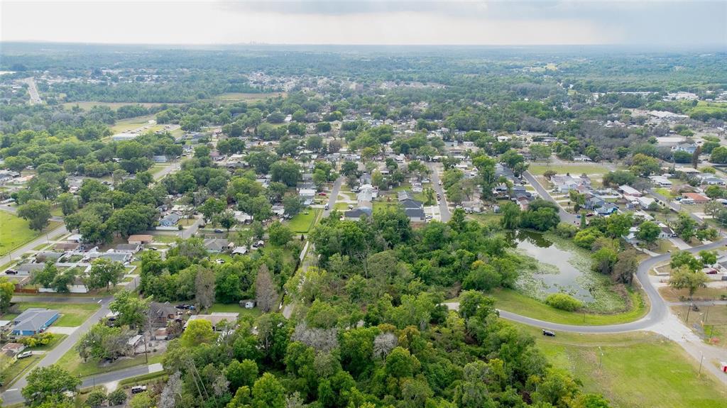 An aerial view shows a suburban neighborhood with houses, dense trees, and a small pond — N SEMINOLE LAKE BLVD, PLANT CITY, FL