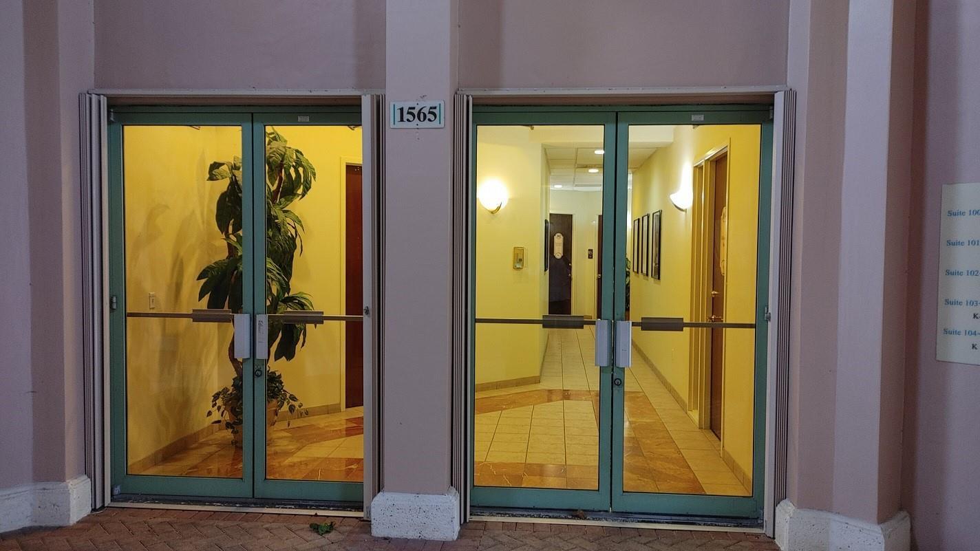 A glass double-door entrance with a building number sign above the center frame — 1565 N Park Drive # 104, Weston FL 33326, WESTON, FL