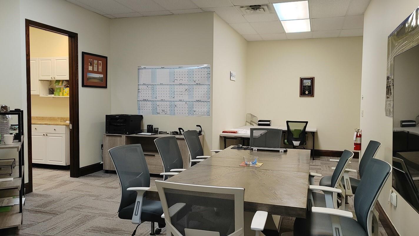 A conference room features a large wooden table, gray office chairs, and a wall calendar — 1565 N Park Drive # 104, Weston FL 33326, WESTON, FL