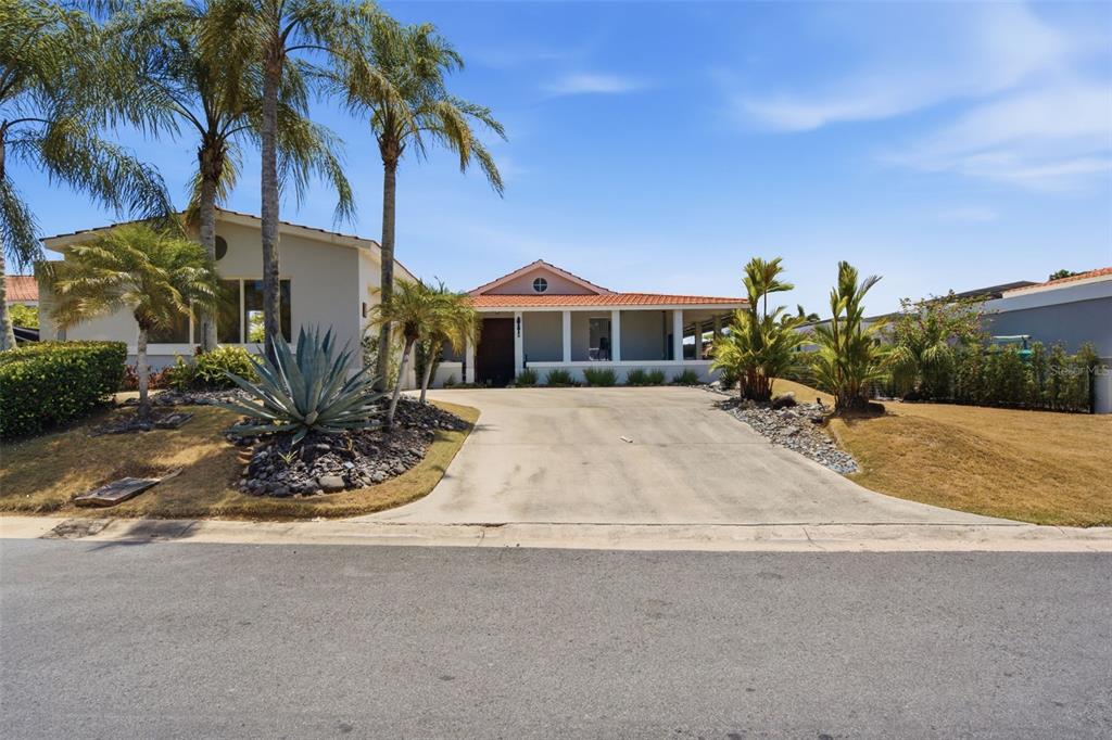 A single-story house with a tiled roof, palm trees, and a concrete driveway — 147 CAMINO DE LOS JUNCOS, DORADO, PR