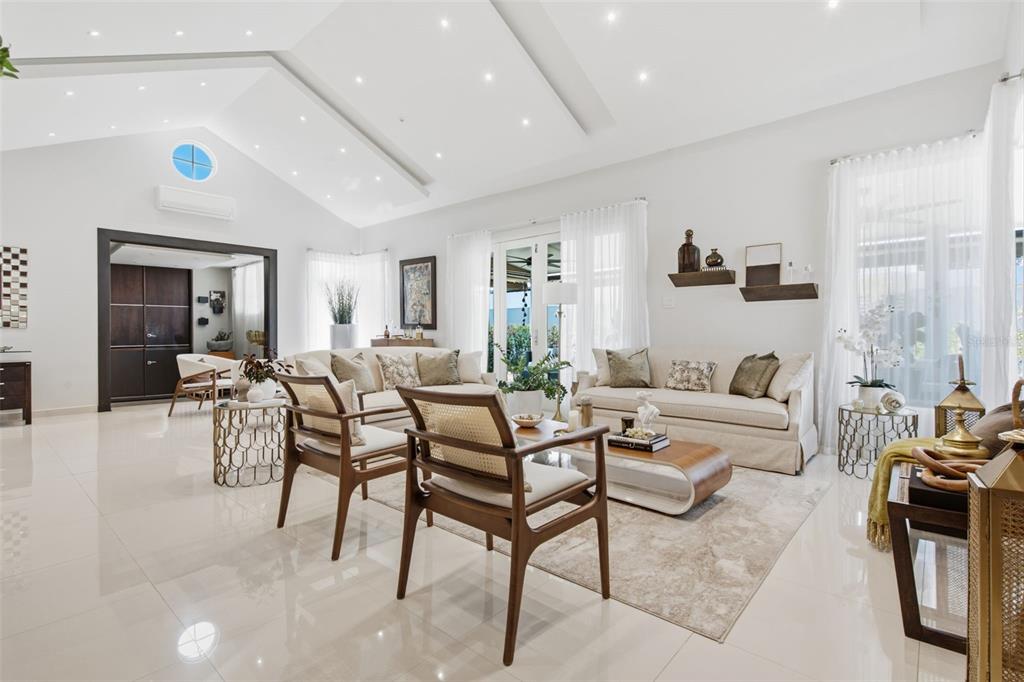 A bright, modern living room features vaulted ceilings, white tile floors, and neutral furniture — 147 CAMINO DE LOS JUNCOS, DORADO, PR