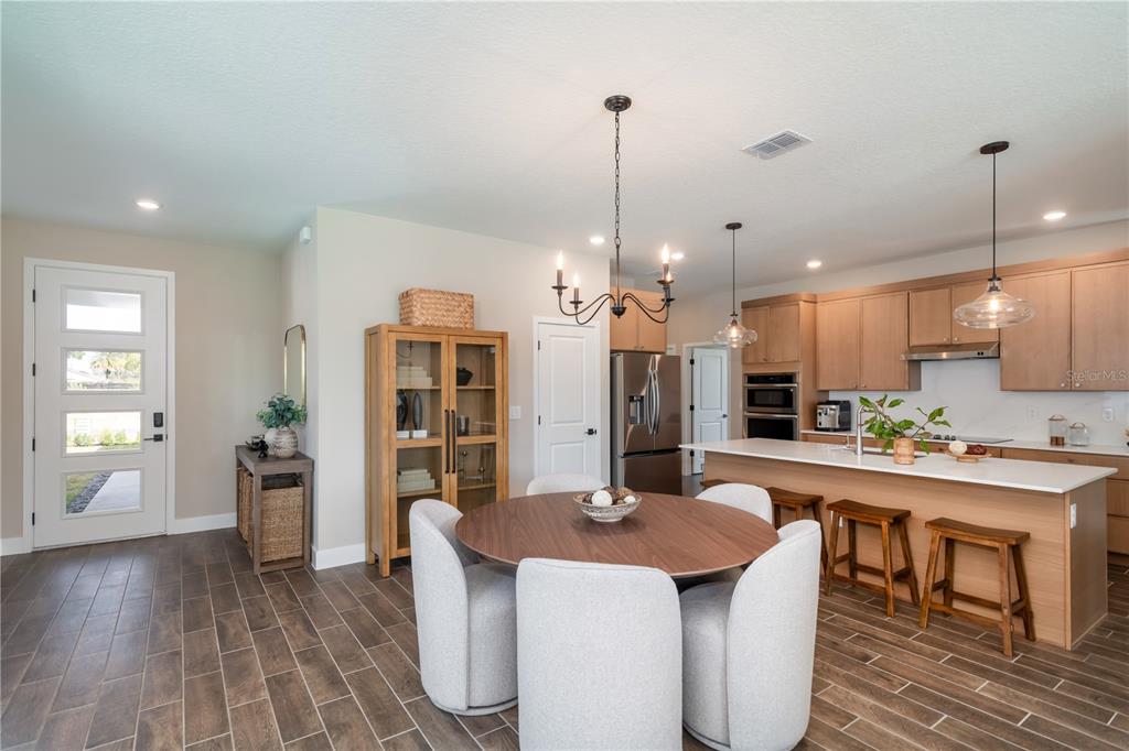 A kitchen and dining area features light wood cabinets, a central island, and tile flooring — 3563 NW 45TH AVENUE, OCALA, FL