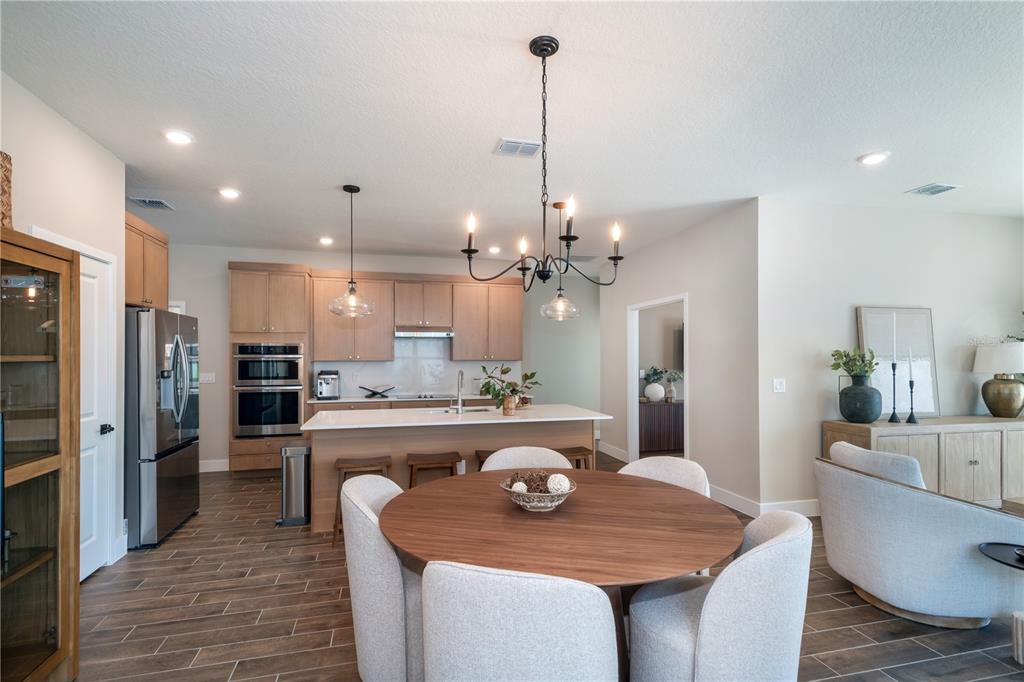 A kitchen with light wood cabinets and a dining area with a round table — 3563 NW 45TH AVENUE, OCALA, FL