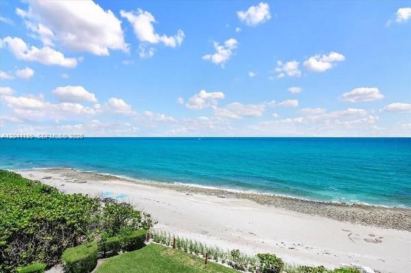 A high-angle view of a sandy beach meeting the turquoise ocean under a blue sky — 4200 N Ocean Dr # 1103, Riviera Beach FL 33404, RIVIERA BEACH, FL