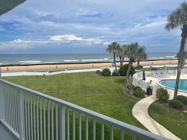 An elevated view of a grassy lawn, swimming pool, and beach from a balcony — 3510 S OCEAN SHORE BOULEVARD UNIT 215, FLAGLER BEACH, FL