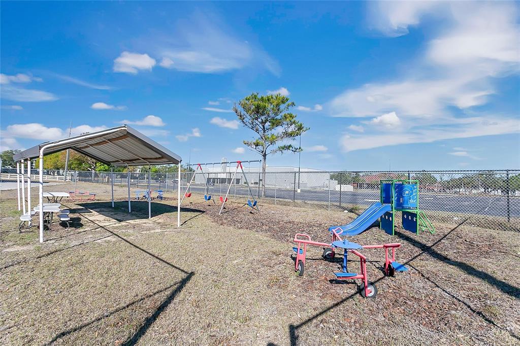 An outdoor playground features a covered picnic area, a swing set, and a small slide — 7429 WEST COLONIAL DRIVE, ORLANDO, FL