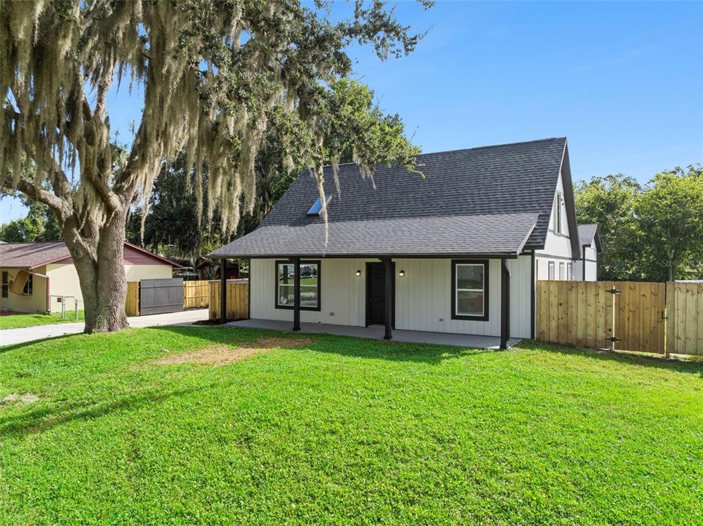 A white house with a dark roof and a front porch sits on a grassy lawn — 2713 VICTORY PALM DRIVE, EDGEWATER, FL